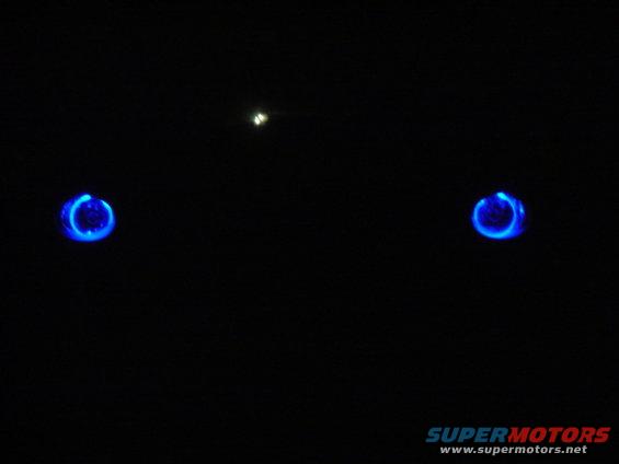 Two blue glowing rings on black background, possibly headlights