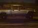 1994 Ford F-150 - A lifted pickup truck is parked on a dirt surface at night, with people visible in the background.