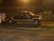1994 Ford F-150 - A dark-colored Ford F-250 Super Duty truck is seen in profile at an outdoor event at night.
