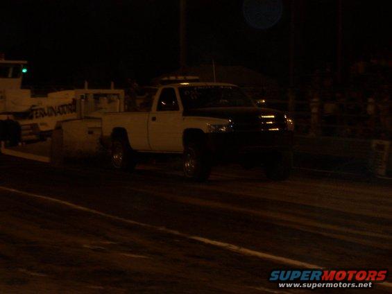 White and black pickup truck with a trailer labeled "TERMINATOR"