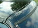 1978 Ford Mustang II - The reflection on the car's surface shows trees and a cloudy sky.