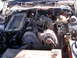 1988 Ford Thunderbird - The engine bay of a car shows the alternator, air intake system, and various engine components under the hood.