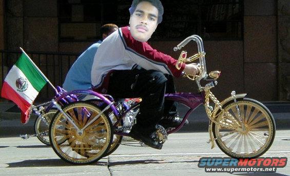 Custom purple lowrider tricycle with gold spokes and a Mexican flag