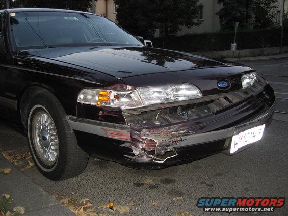Dark sedan's front bumper is heavily damaged. 1992 Ford Crown Victoria