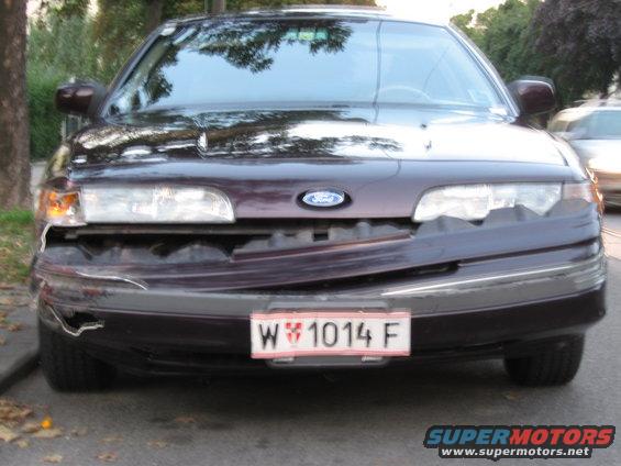 Dark purple 1992 Ford Crown Victoria with a damaged front bumper and grille, seen from the front