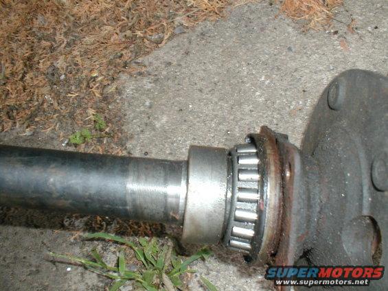 Axle shaft with roller bearing and flange, resting on ground