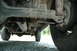 1972 Ford Bronco - The undercarriage of a vehicle, focusing on the rear suspension and exhaust components.