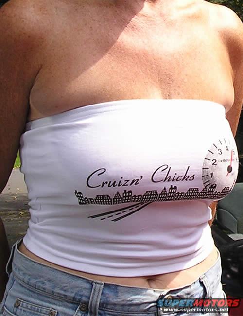 Woman in white strapless top with 'Cruizn Chicks' text and city skyline graphic, denim jeans