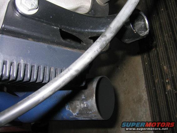 Close-up of a motorcycle's exhaust pipe and a ribbed engine component