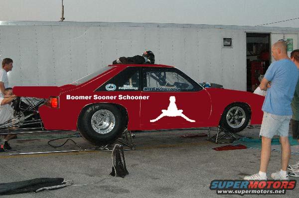 Red drag car with white Jordan logo and text 'Boomer Sooner Schooner', side view