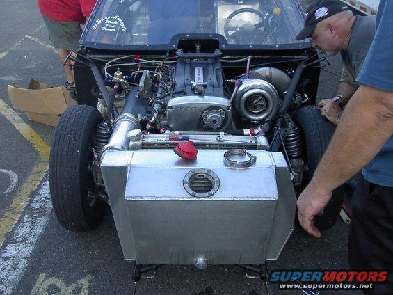 Custom race car engine bay with large turbocharger and aluminum tank