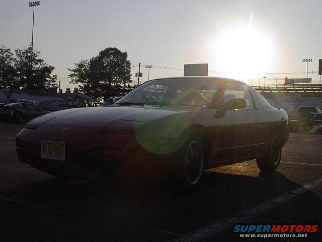 Red Nissan 240SX coupe with a yellow license plate parked at sunset