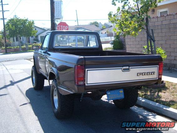 Brown Ford Ranger pickup truck, rear view, lifted suspension