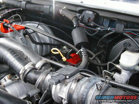 Engine bay with air intake, hoses, and engine components visible. Some text on a black box reads 'CRUISE CONTROL MODULE'