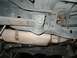 1989 Ford Bronco - The underside of a vehicle shows its exhaust system and suspension components.