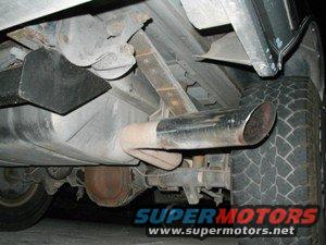 Underside view of vehicle exhaust and tire. Supermotors.net logo visible