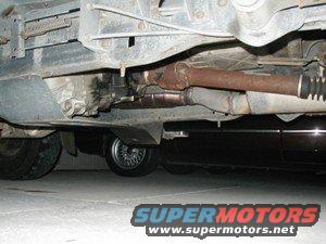 Underside view of a vehicle's drivetrain, with another vehicle visible below