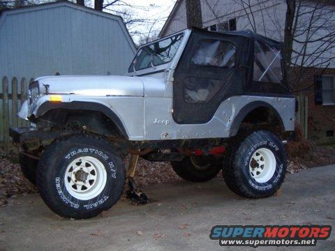 Silver 1978 Jeep CJ5 with a black soft top, lifted suspension, and white-rimmed wheels