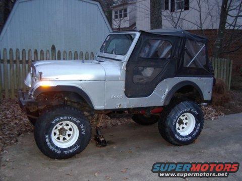 1978 Jeep CJ5, silver with black soft top, lifted suspension, white rims, parked outdoors