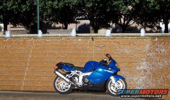 Blue 2005 BMW R1200CA ABS motorcycle parked by a brick fountain with water cascading