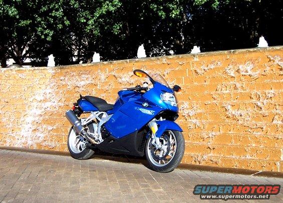 Blue 2005 BMW R1200CA ABS motorcycle parked on brick pavement next to a textured orange wall