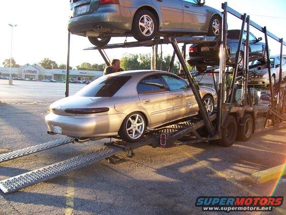 Gold 1998 Mercury Sable sedan on car carrier, rear view