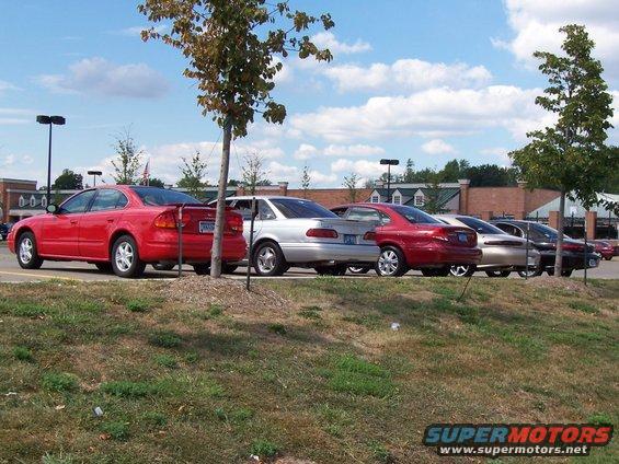 Red 1998 Mercury Sable sedan parked in a lot, side view