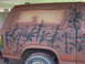1982 Ford Bronco - SUV side view with camouflage leaf pattern, windows taped off for painting.
