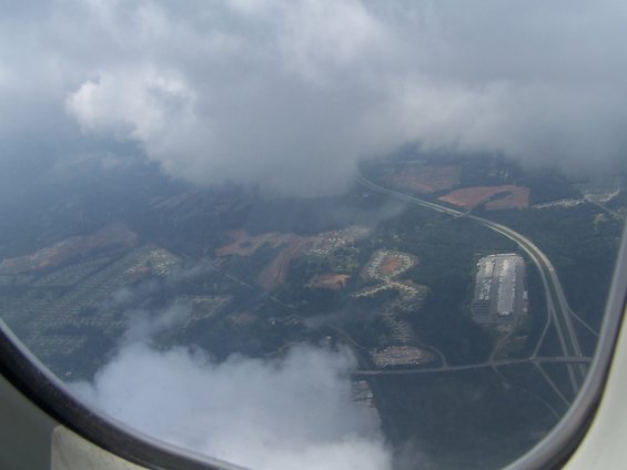 Aerial view of landscape with clouds partially obscuring the ground below
