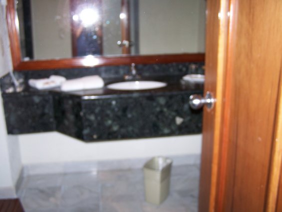Bathroom vanity with dark green granite countertop and white sink