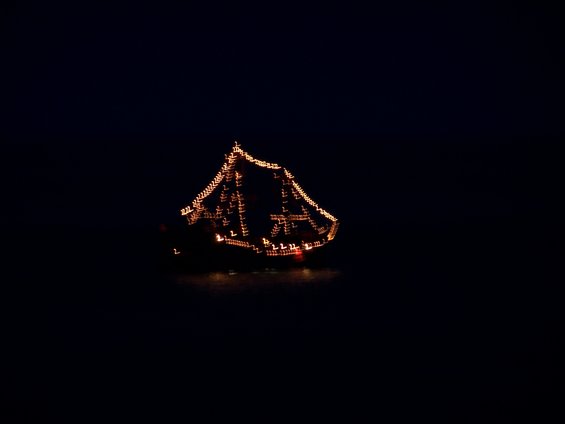 Boat decorated with orange lights at night, blurred