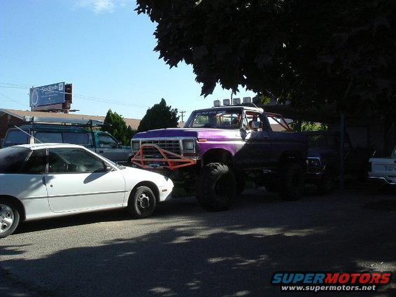 Purple lifted 1979 Ford Bronco with orange bumper guard and light bar