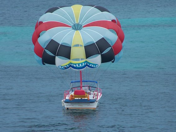 Boat pulling a colorful parachute for parasailing over the water