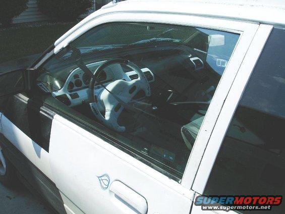 Interior view of a white car with a light-colored dashboard and steering wheel
