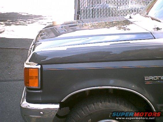 Dark gray 1990 Ford Bronco fender and hood detail with chrome trim