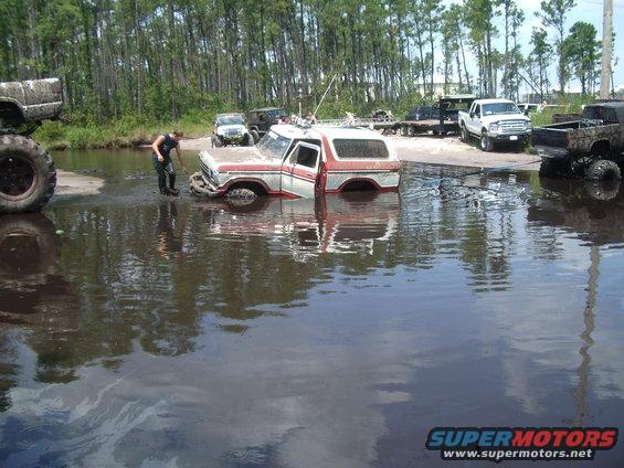 Ford Bronco stuck in water with other off-road vehicles around