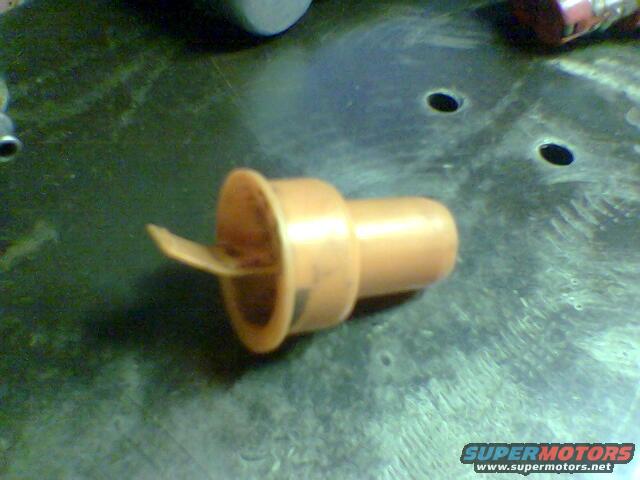 Orange spark plug boot on a textured surface