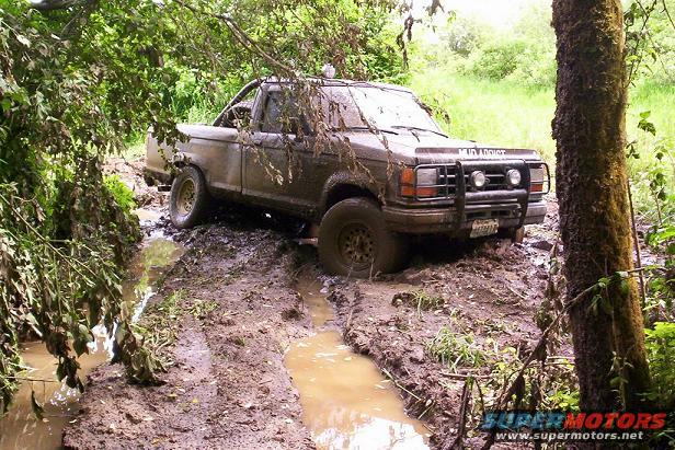1992 Ford Ranger stuck in a muddy trail with trees and foliage around