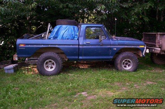 Blue 1977 Ford F-150 pickup truck, side view, with a tarp covering the bed