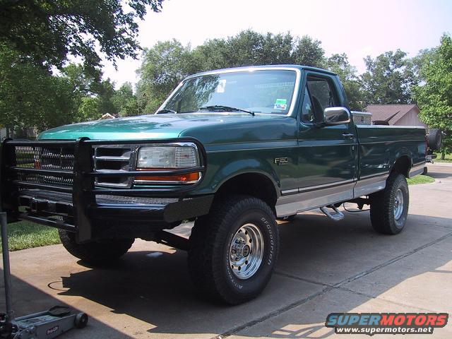 Green Ford F-250 truck with aftermarket brush guard and BFGoodrich tires