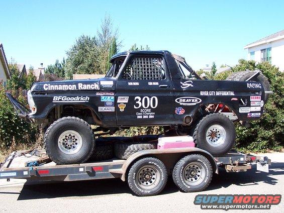 Black 1979 Ford Bronco race truck with "Cinnamon Ranch" and "BFGoodrich" decals, number 300, on a trailer