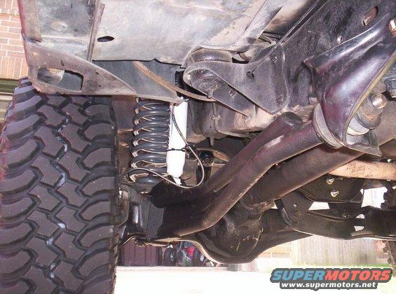 Undercarriage view of a 1984 Ford F-150 showing lifted suspension and large tires