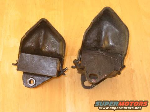 Two dark engine mounts on a wooden surface. Supermotors.net logo visible