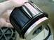 2002 Ford F-250 - A black fuel filter with a silver base is held by a hand, with another filter component visible in the background.