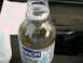 2002 Ford F-250 - Draining fuel filter into a water bottle, with a portion of a Ford engine in the background.