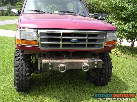 Red Ford Bronco with aftermarket bumper and large tires