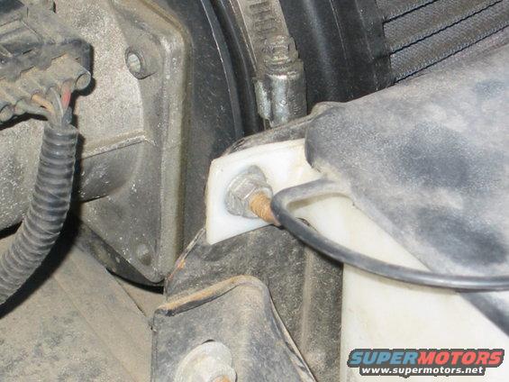 for the driver's side, same song except you need to remove the radiator overflow and washer fluid bay.  
IE - this nut and for me a zip tie on the other side.  