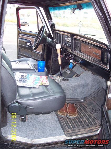 Interior of a 1979 Ford Bronco, showing the driver's seat, dashboard, and floor
