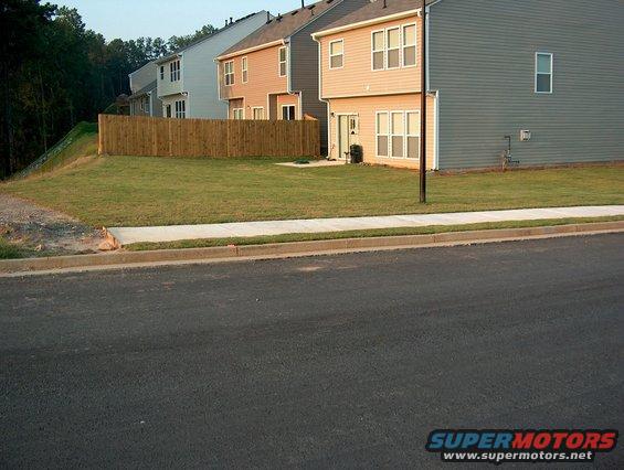 Residential street with houses and a wooden fence