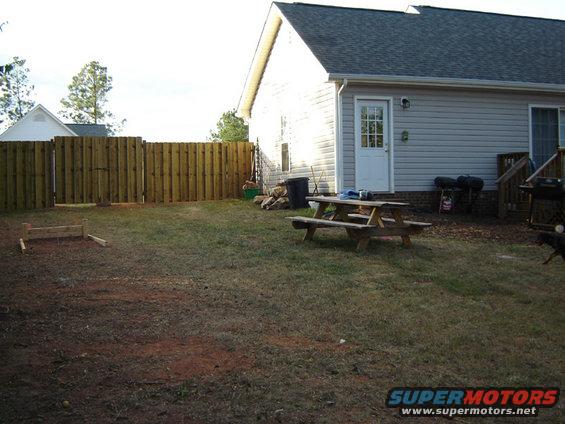 Backyard with wooden fence, picnic table, and house